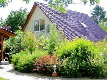 Ferienwohnung Trojan - Sicht auf Ferienwohnung und Terrasse vom Garten aus.